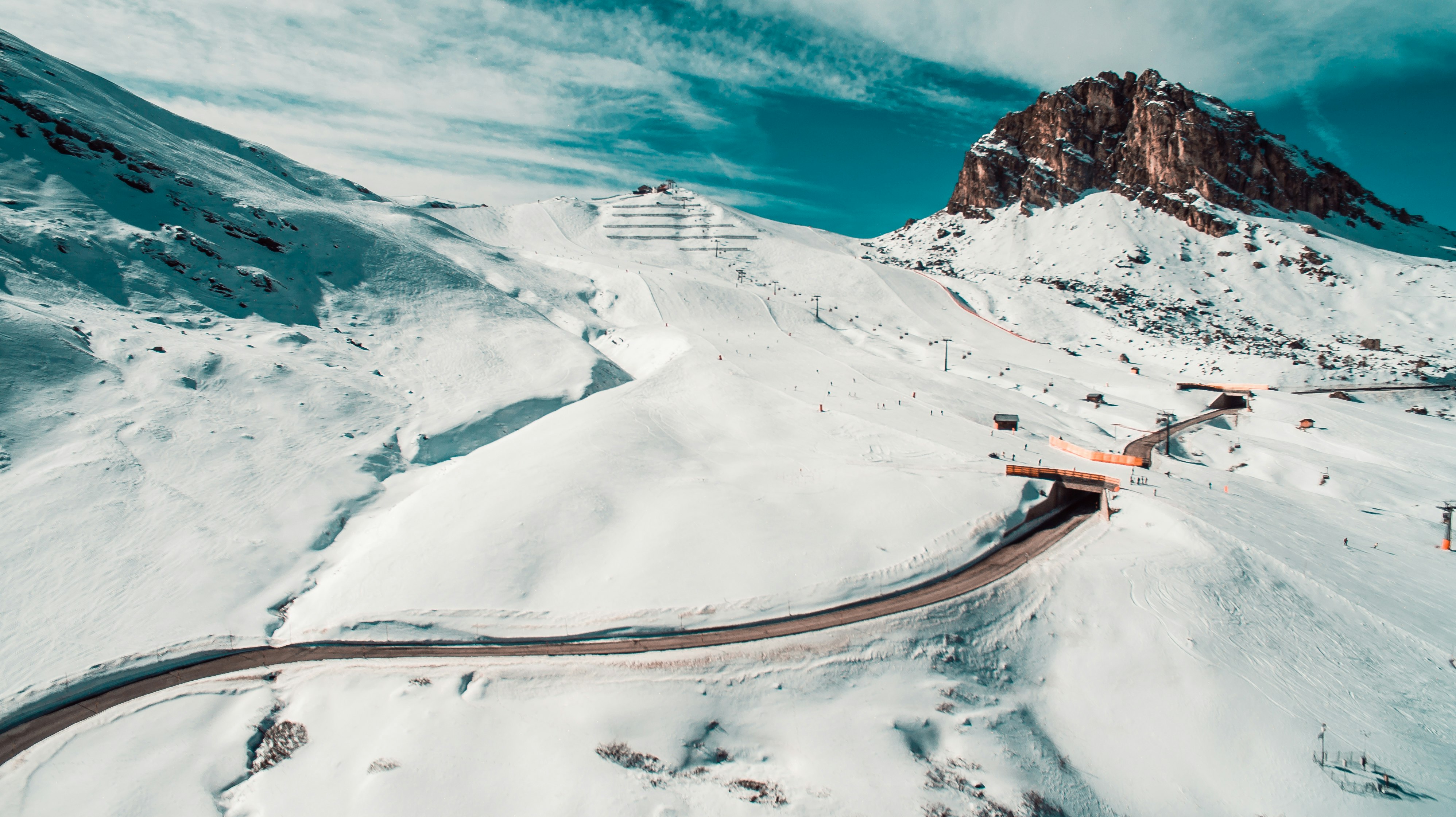 aerial view of road surrounded by mountain covered by snow